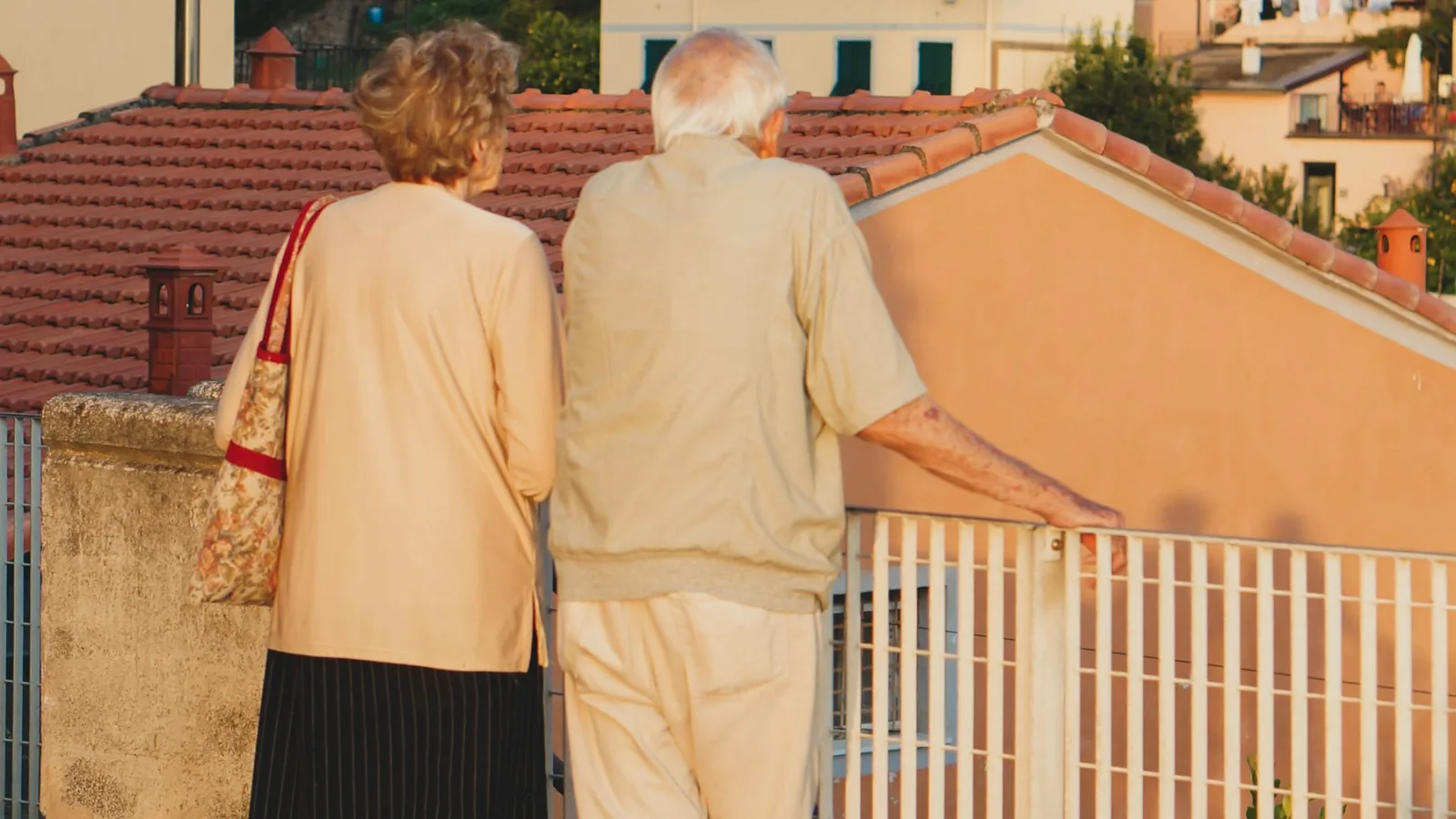 Couple de personnes âgées de dos regardant l'horizon depuis une terrasse